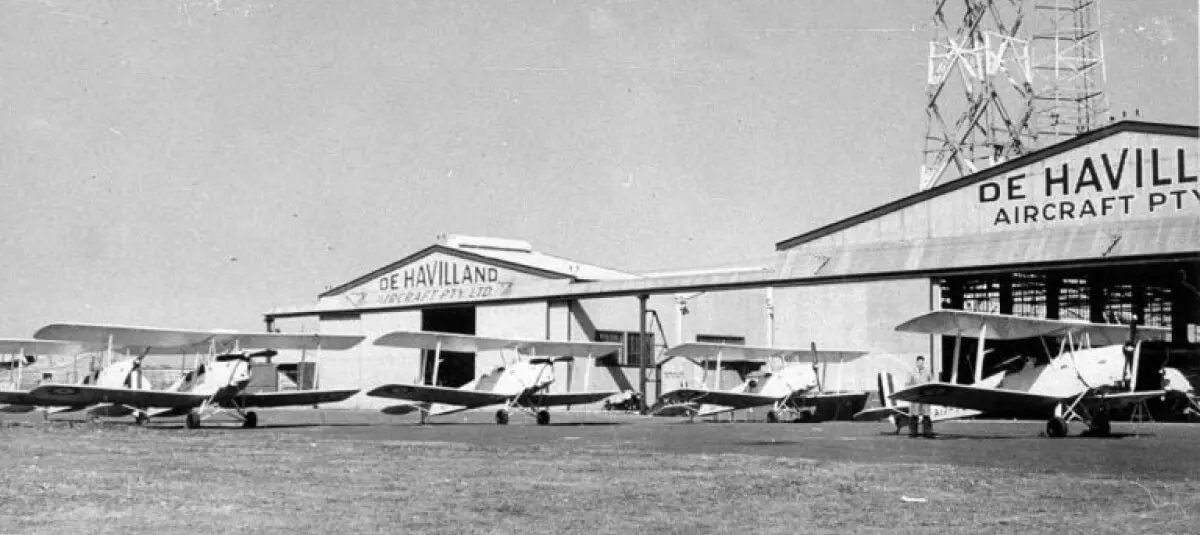 A historic black-and-white image of several aircraft parked outside the De Havilland factory