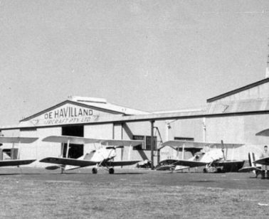A historic black-and-white image of several aircraft parked outside the De Havilland factory
